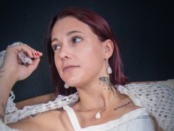 Célenna pose pour le photographe Stéphane Faraut avec un ensemble de bijoux en quartz blanc à la pureté cristalline.