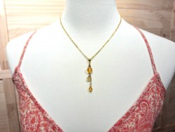 Pendentif en métal doré avec perles de citrine véritable sur robe d'été à motifs pour une touche de lumière.