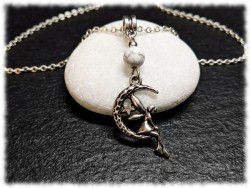 Pendentif fée argentée : un symbole de métamorphose et de sérénité, niché au cœur d'un croissant de lune protecteur.