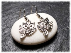 Boucles d’oreilles crochets chouette argentée rappelant les figures mythiques des légendes et récits anciens.