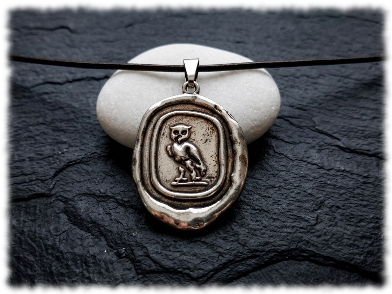 Cordon noir avec pendentif argenté de la chouette de Pallas Athena, un bijou parfait pour les femmes comme les hommes qui aiment les légendes et les histoires anciennes.