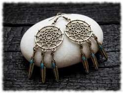 Ces boucles d'oreilles attrape-rêves au design soigné filtrent l'atmosphère pour ne garder que la lumière et la diffuser.