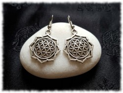 Ces boucles d'oreilles Fleur de Vie argentées captent la lumière sur leurs arêtes au motif de fleur de lotus.