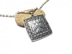 Un talisman à l'aigle au graphisme natif américain, sur un sautoir grosse chaîne argentée pour homme